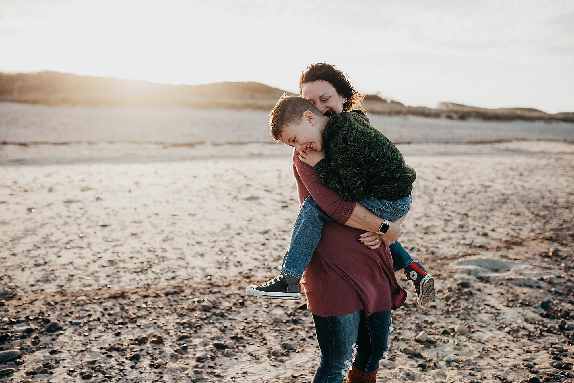 a mother holds her young son on the beach during their session with Cape Cod family photographer, Allison Wolf