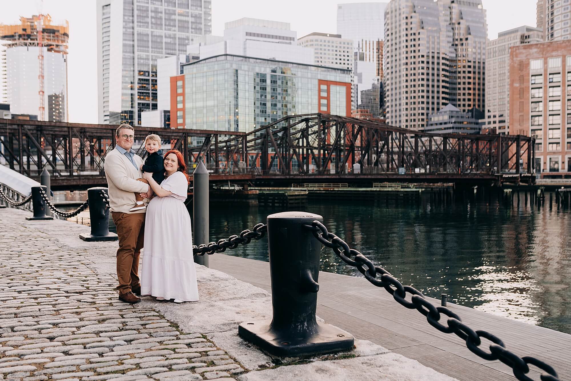 a family at the seaport poses for a photo during their boston maternity photographer session