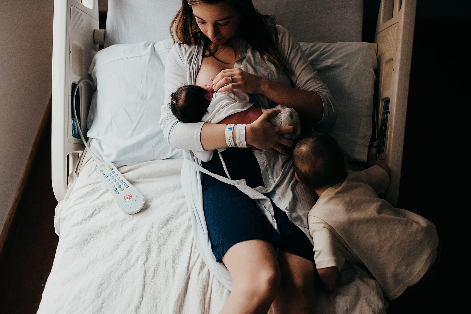 A mother breastfeeds her new baby in her hospital room