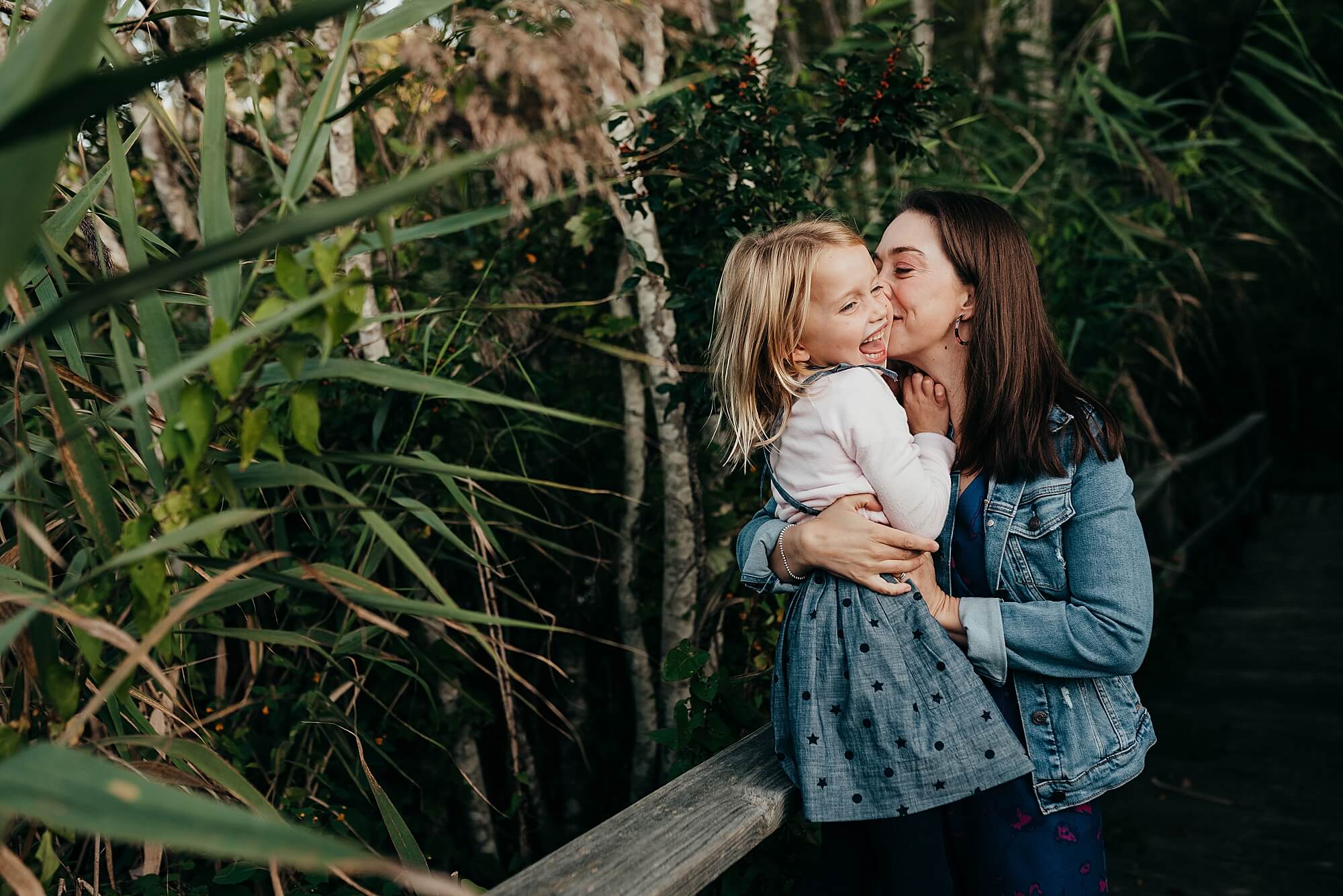 A mother kisses her young daughter's cheek