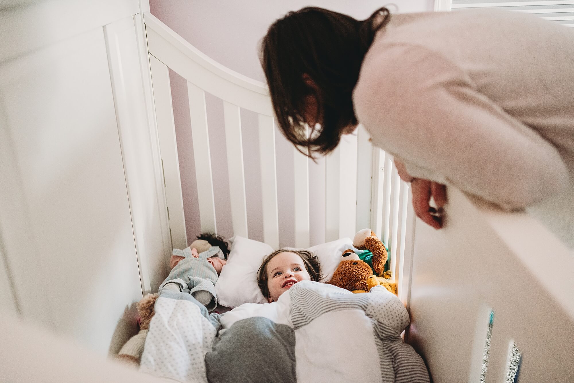 A mother puts her toddler daughter down for a nap