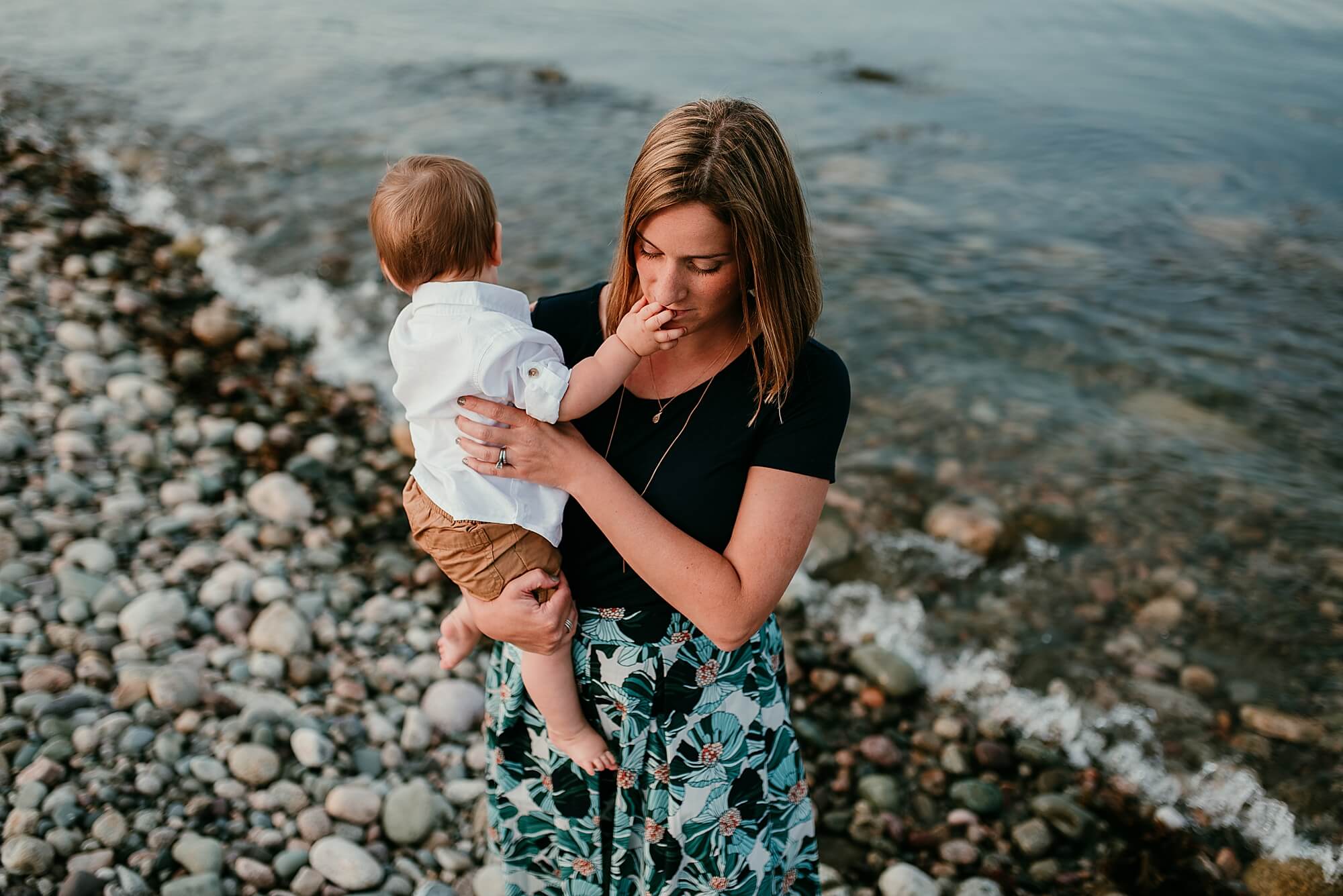 A mother holds her toddler son near the ocean in Scituate