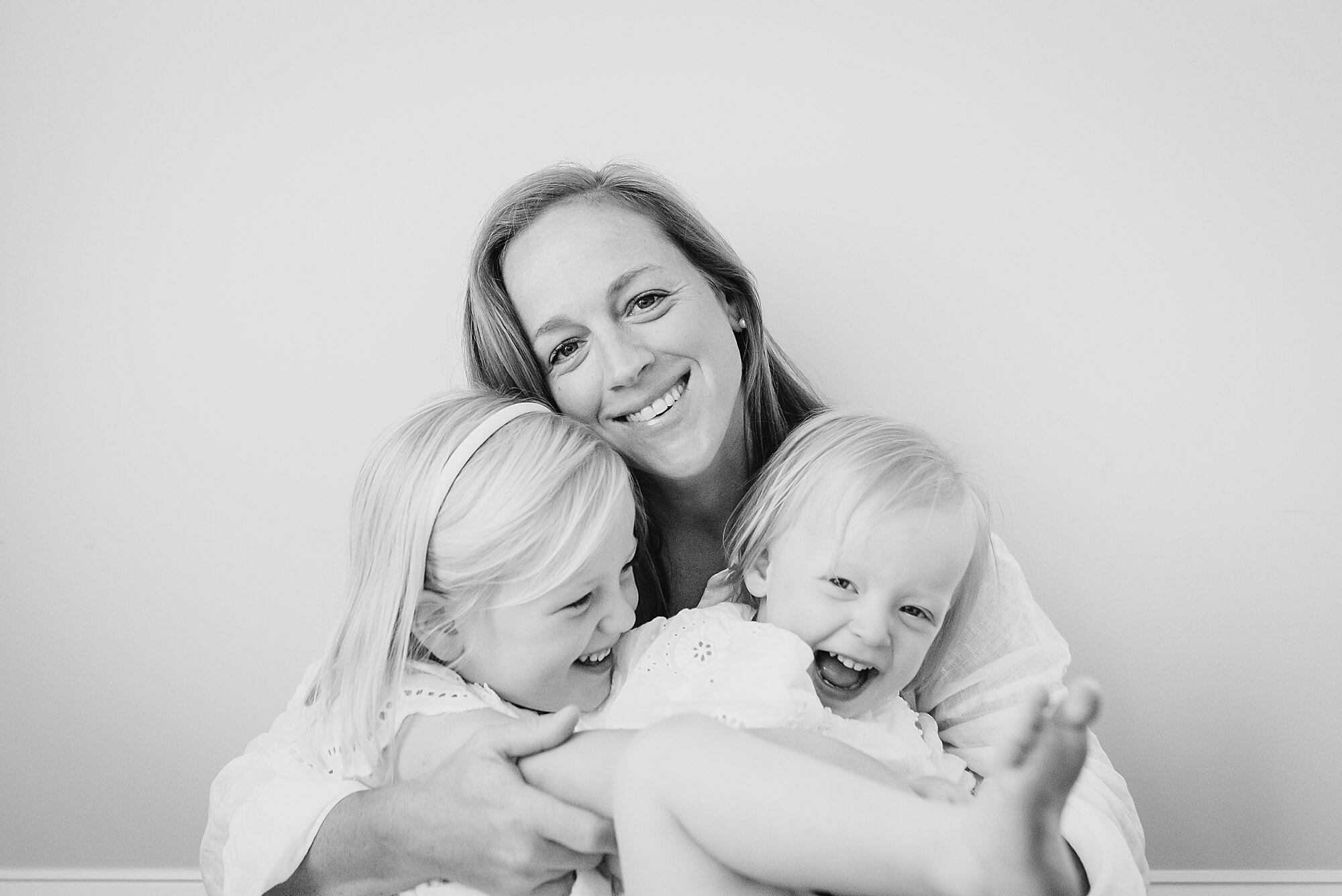 A black and white image of a mother with her young daughters