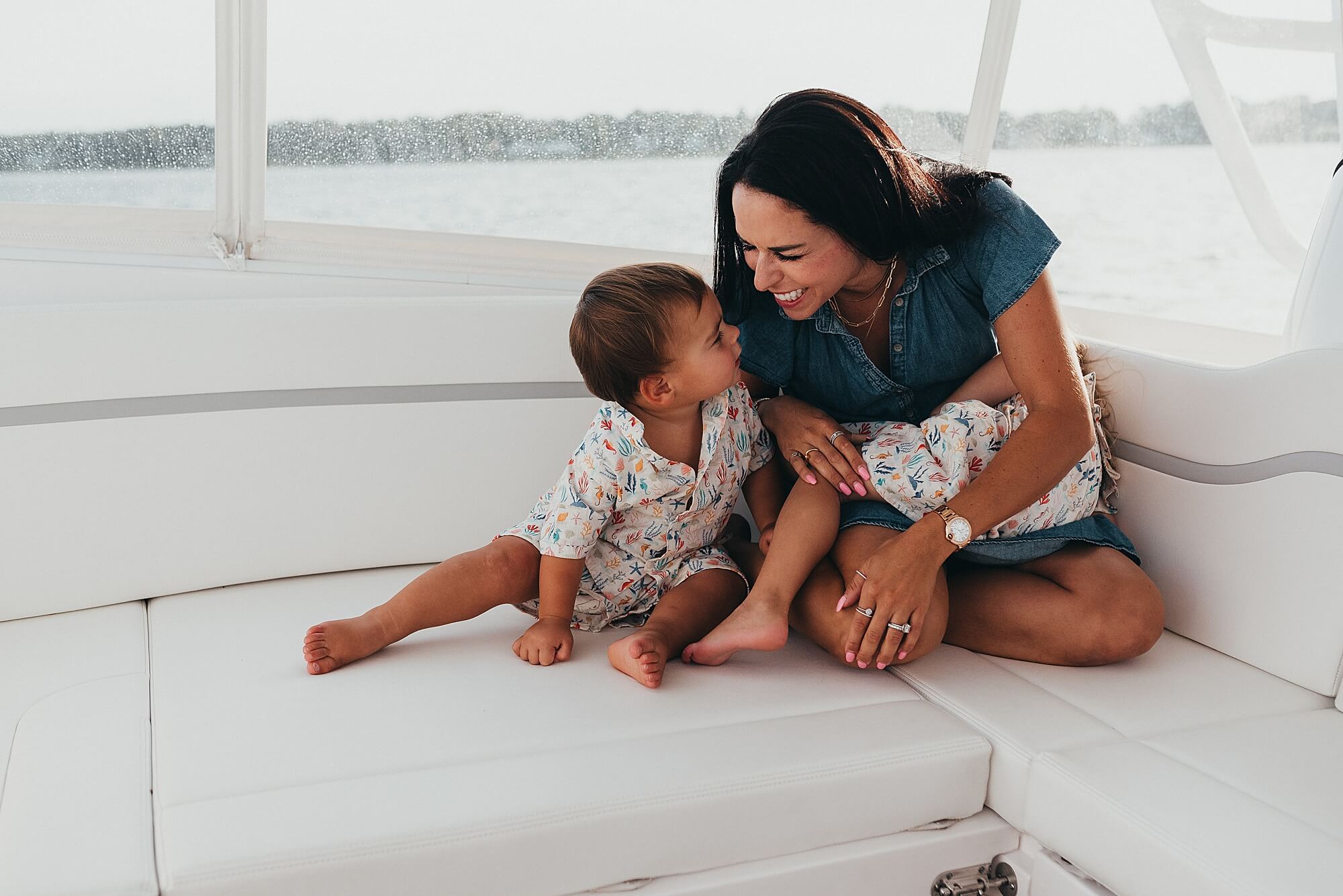 A mother laughs with her young children on a boat in Marion MA