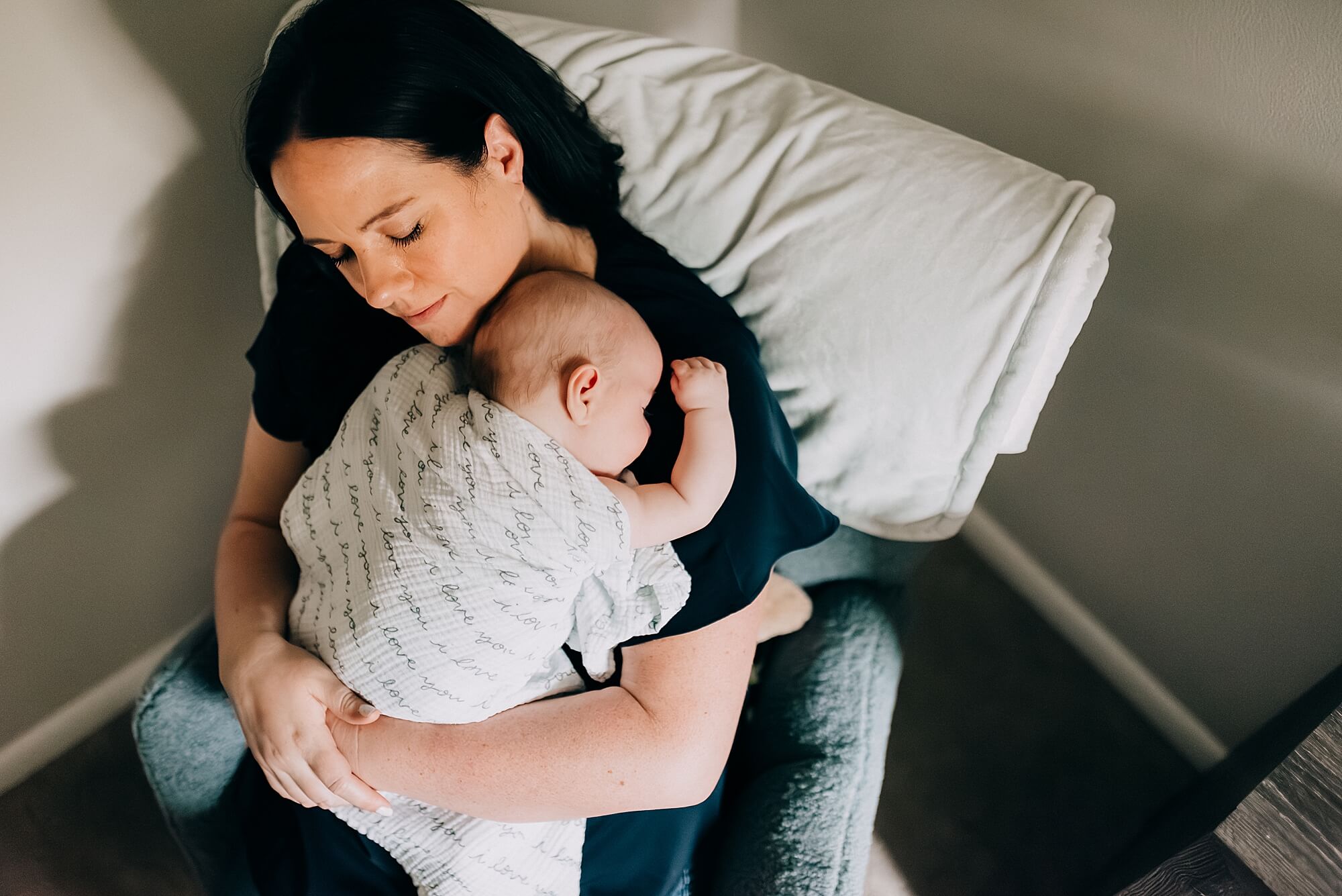 A mother holds her young son in his nursery