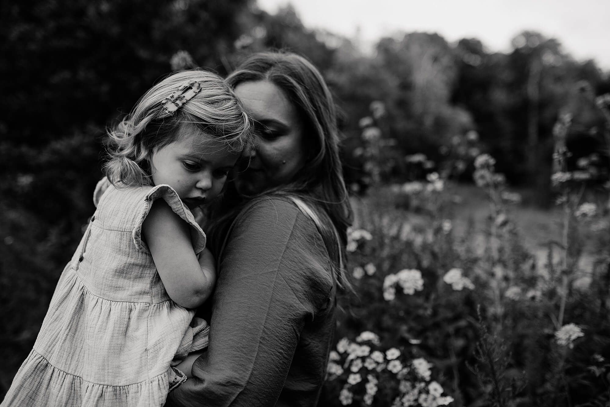 A black and white image of a mother holding her toddler daughter