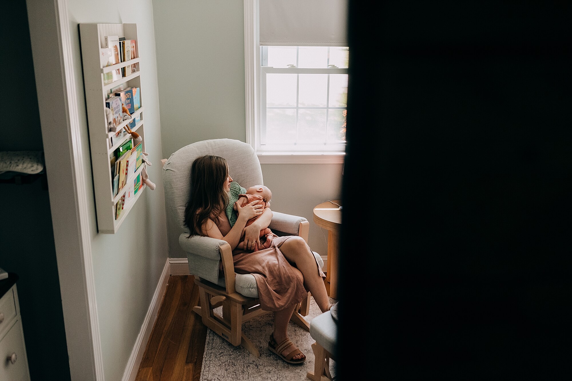 A mother holds her newborn baby in her nursery. A portrait of Motherhood