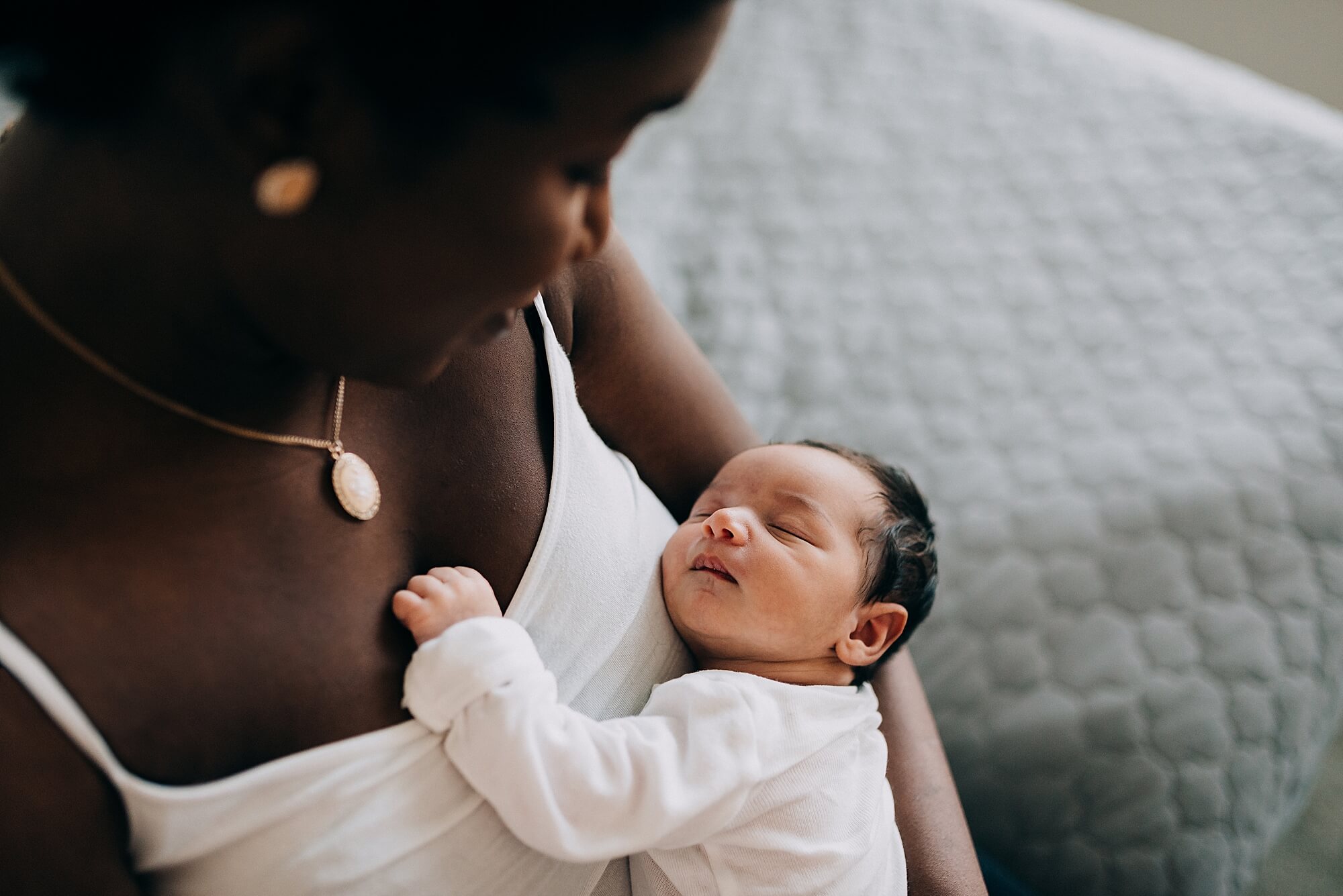 A Black mother snuggles her newborn baby