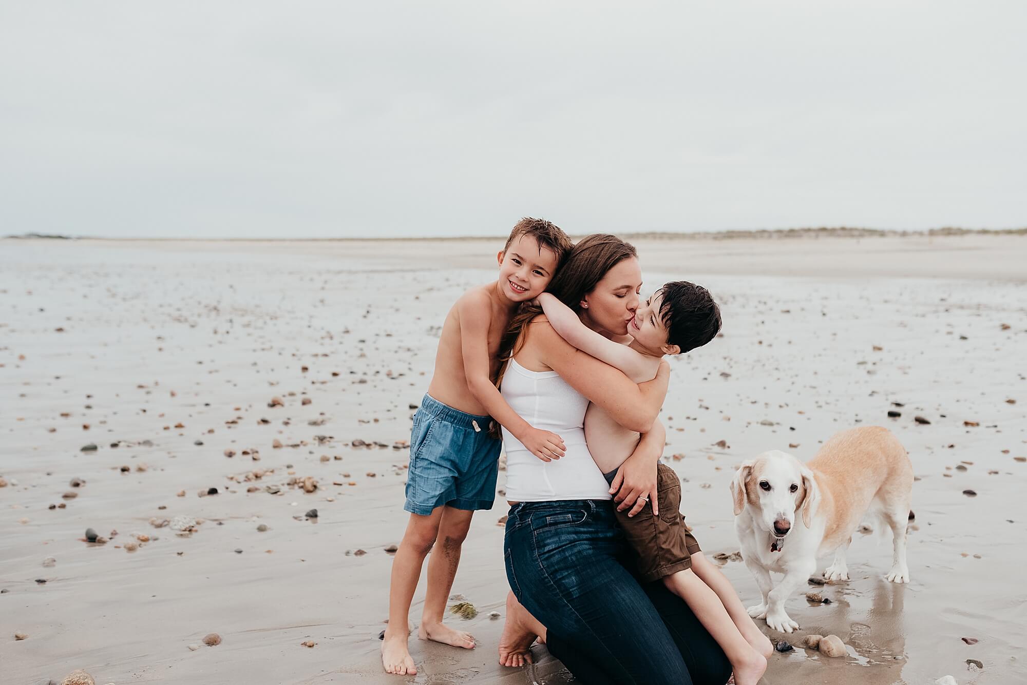 A mother at duxbury beach beach with her young sons and dog