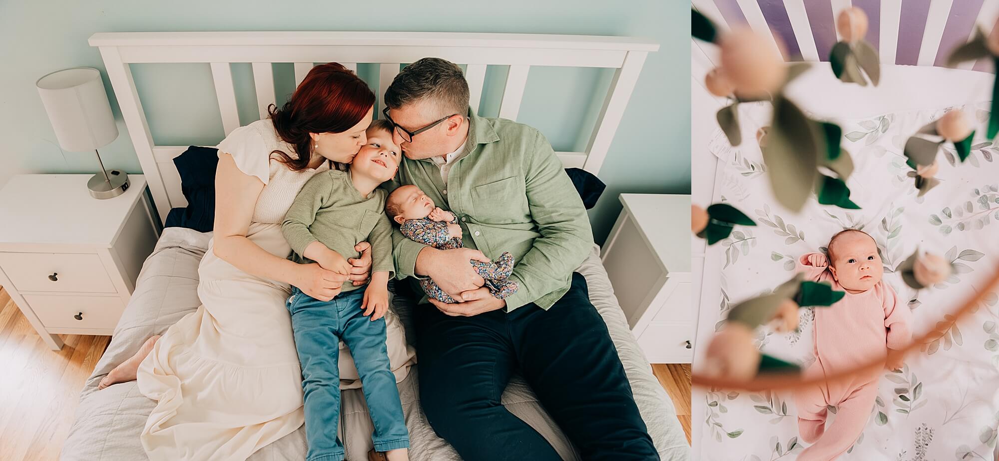 Family of four sitting together on a bed with their newborn and toddler, laughing and cuddled up.