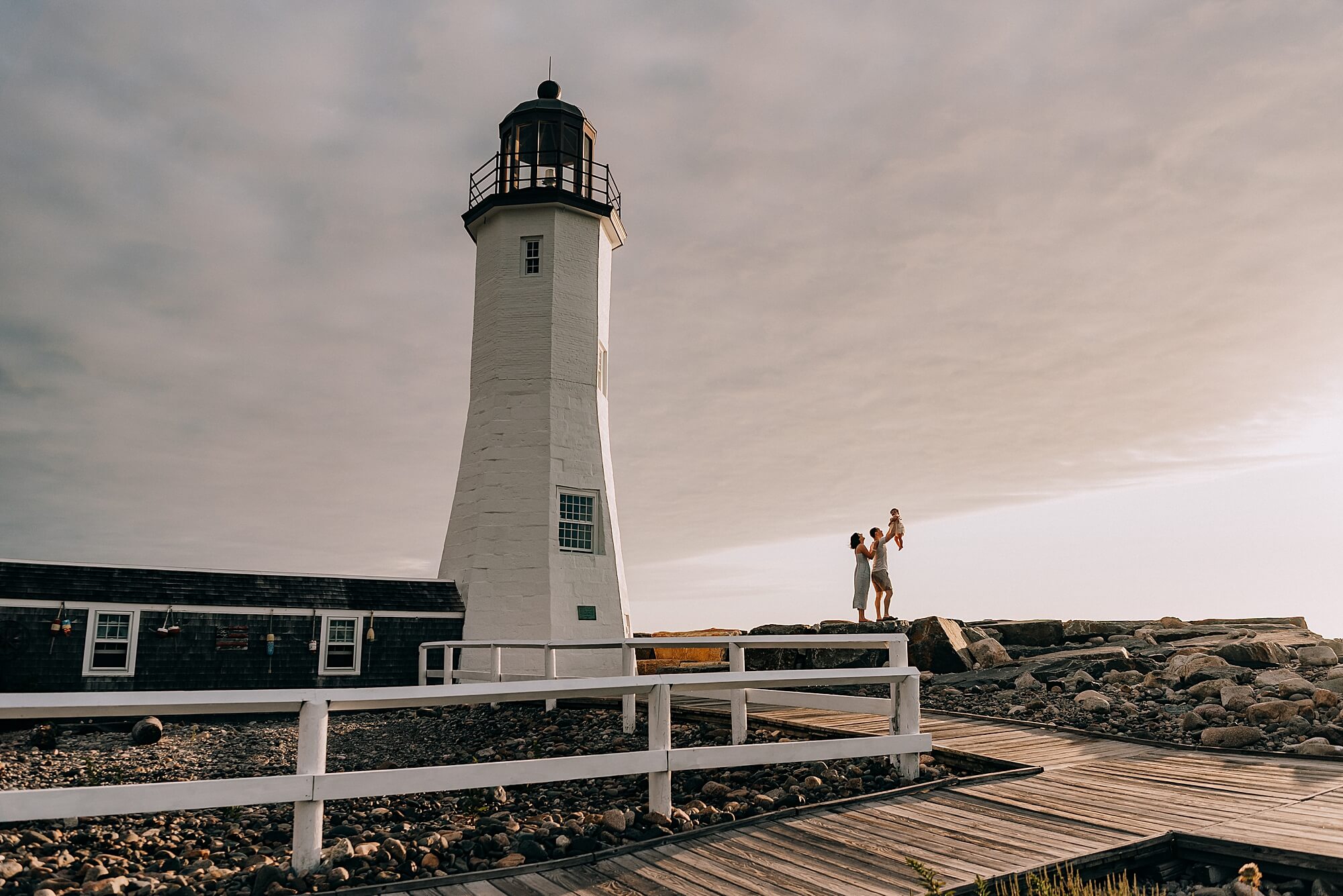 Family next to Scituate Lighthouse at sunrise with Allison Wolf Photography