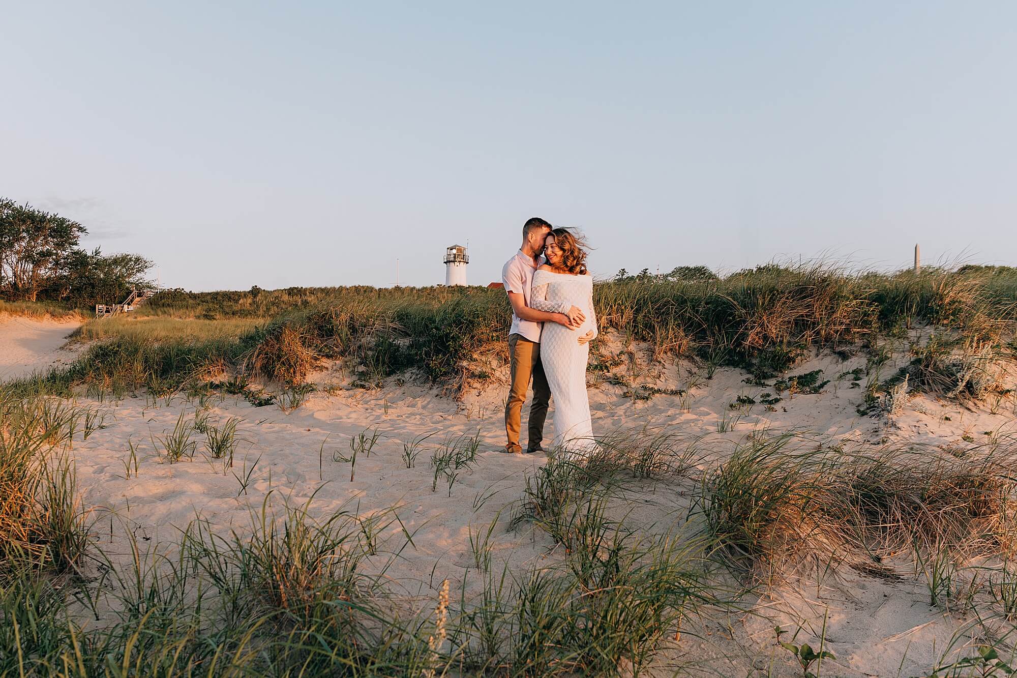 Couple expecting twins snuggle at the Chatham Lighthouse during their maternity session with Cape Cod family photographer, Allison Wolf