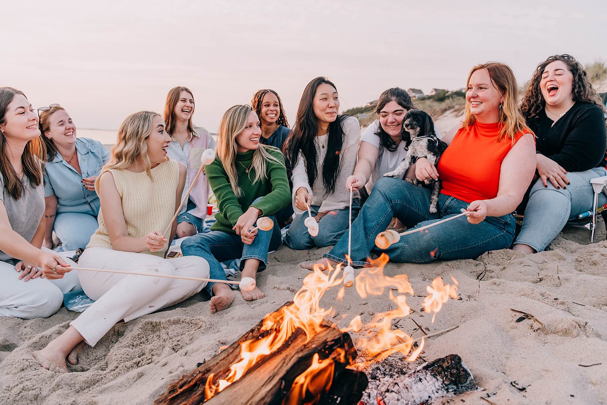 A group of friends have fun on the beach in Truro MA with a fire and marshmallows