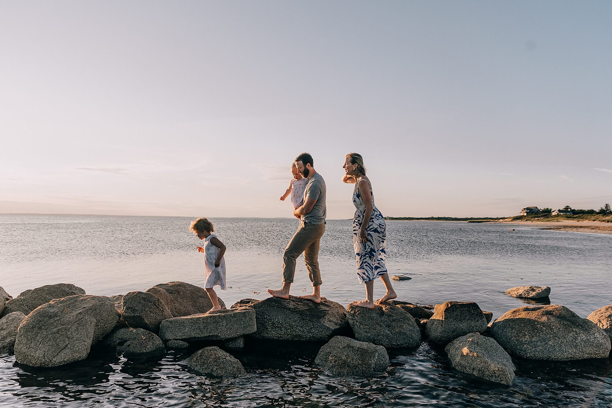 Family walking along the rocks in Falmouth during their session with Cape Cod Family Photographer Allison Wolf