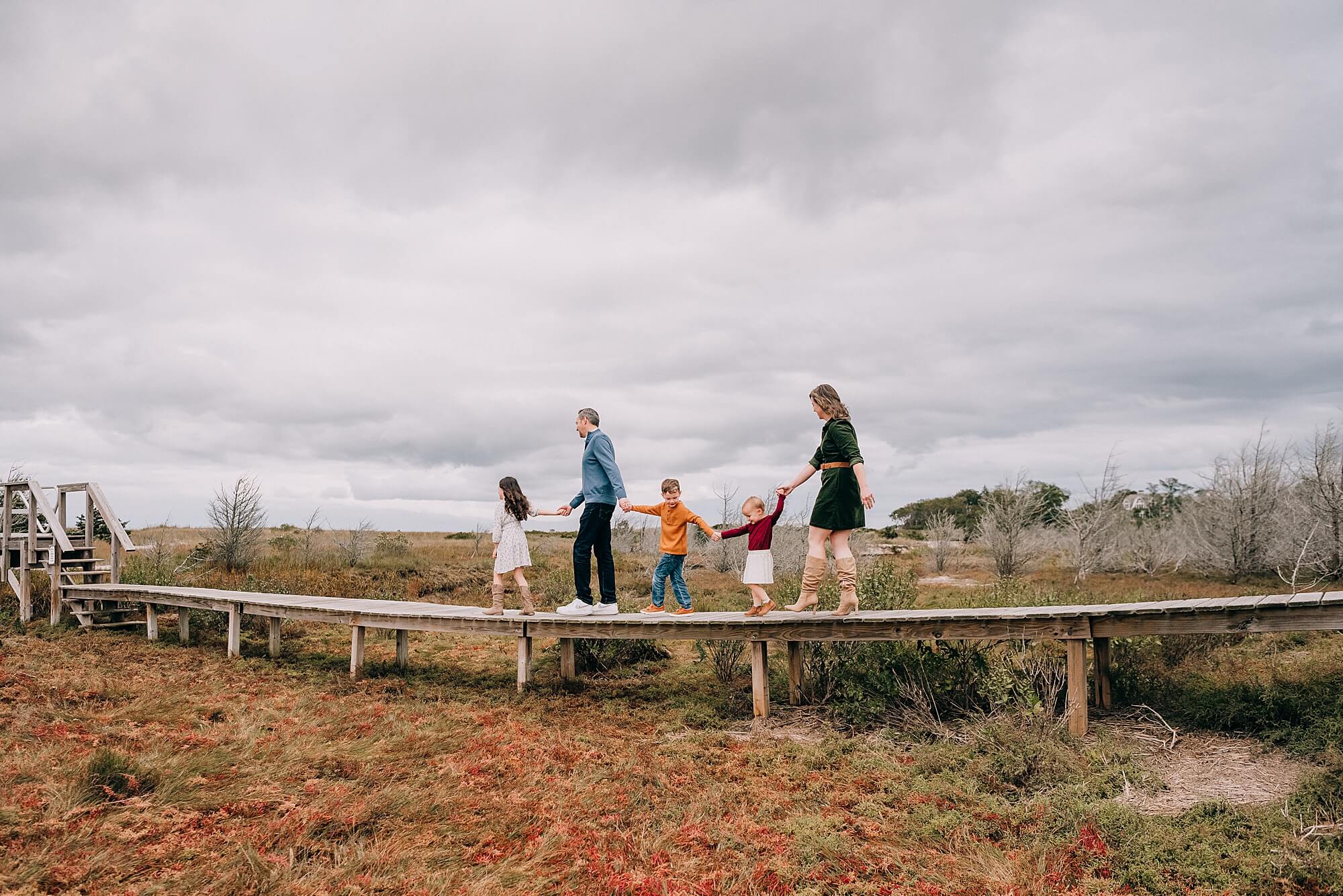 Family walks along a bridge in Brewster MA during their Cape Cod family session