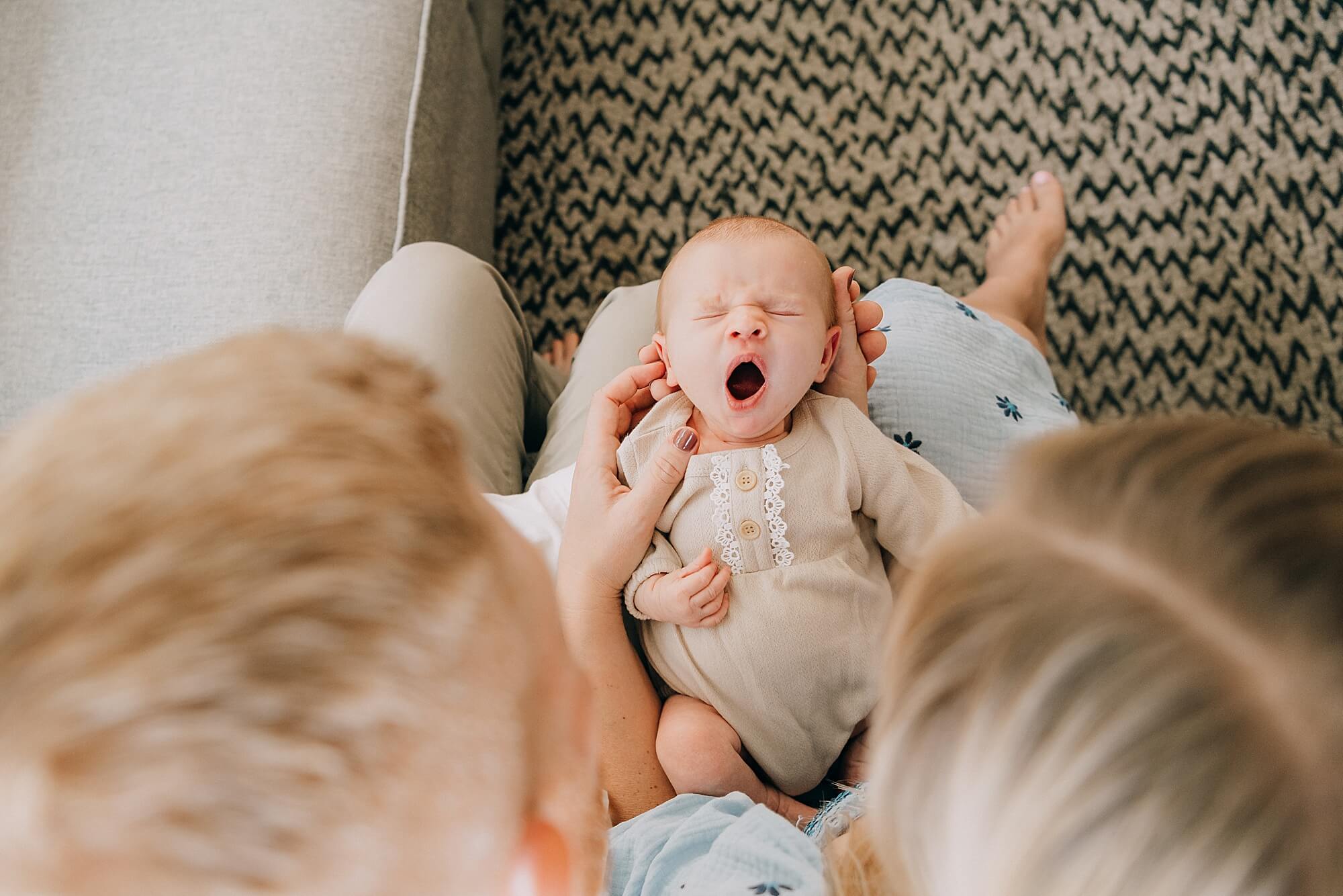 A newborn girl yawns adorably during her photo session with South Shore MA Newborn Photographer Allison Wolf