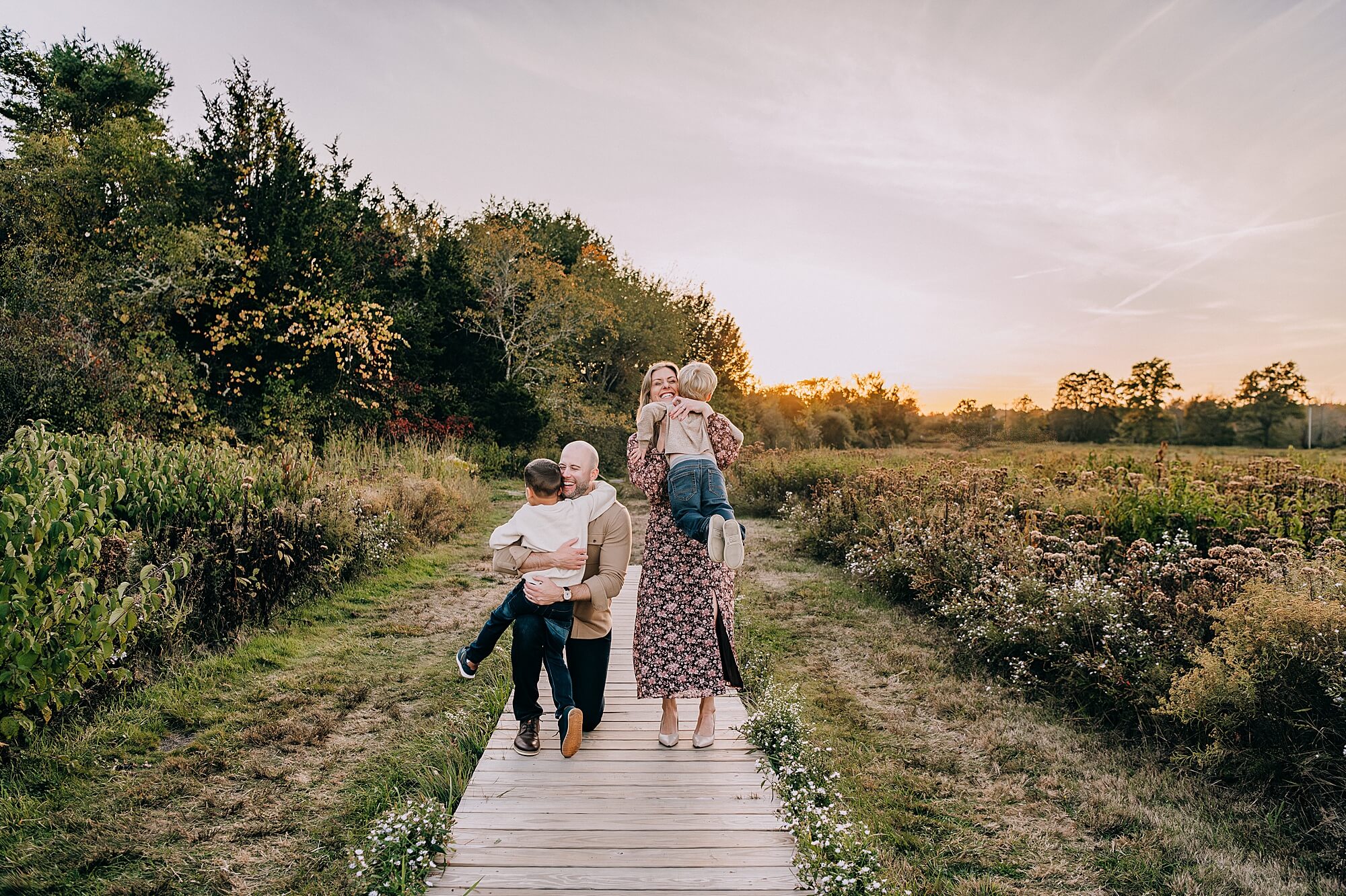 A family with two boys have a lot of fun running around at sunset during their photos with Duxbury MA Family Photographer Allison Wolf