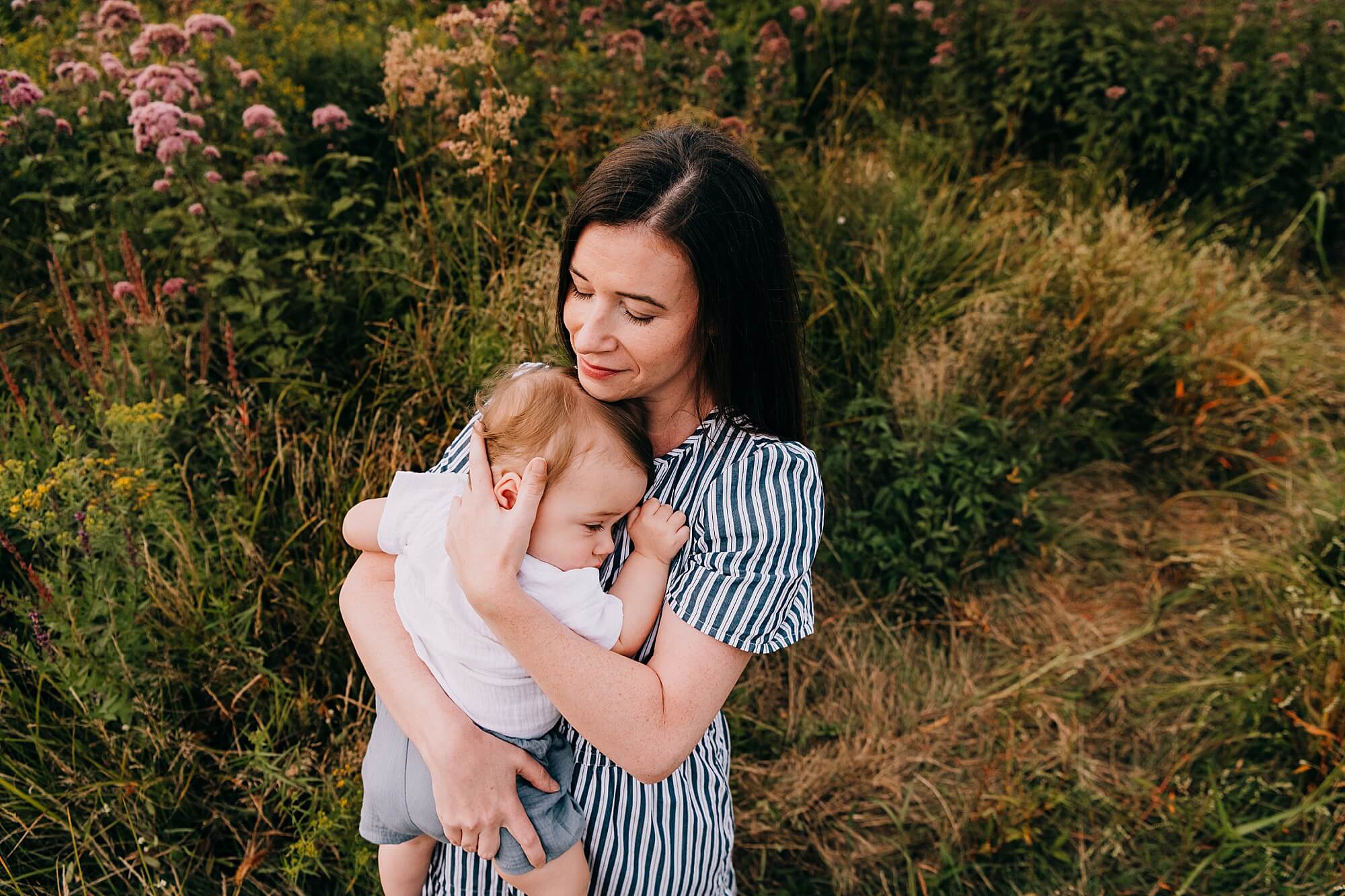 A mother snuggles her son in a wildflower field in Duxbury MA